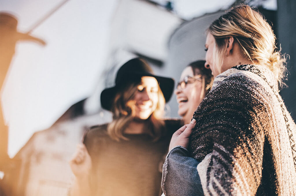 Eine Gruppe von Frauen, die sich unterhalten und dabei lachen.